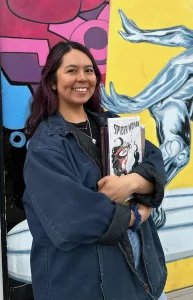 Nicole Barraza standing in front of a comic book mural